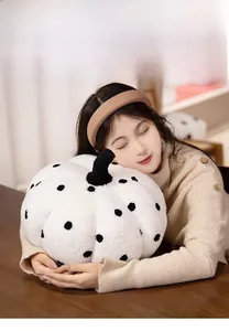 Close-up of soft white teddy velvet pumpkin pillow with black polka dots for home decor