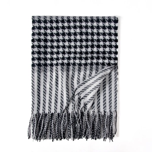 Soft black and white houndstooth scarf with stripes and tassels on white background