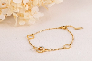 Detail of gold titanium steel bracelet featuring rhinestone O-rings and lobster clasp