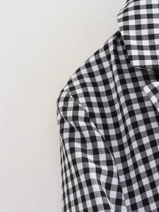 Detail of black and white gingham woven fabric on shoulder and collar of the blazer