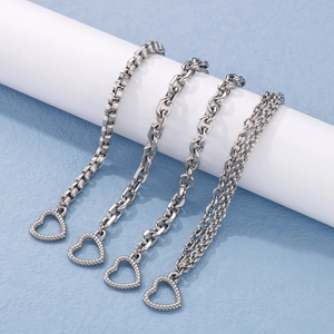 Detailed view of silver heart-shaped toggle clasps on various layered chain styles