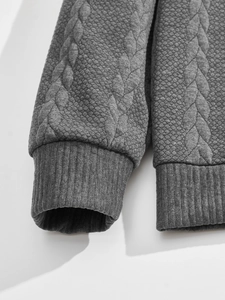 Close-up of gray textured knit fabric with ribbed cuffs and geometric jacquard pattern