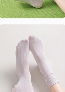 Close-up of white mesh silk socks showing breathable texture and ruffled cuff details