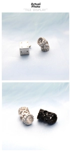Detailed view of vintage silver dice charm and black skull hollow beads for DIY jewelry