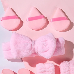 Close-up of pink flannel headband with bow and soft triangular powder puffs set