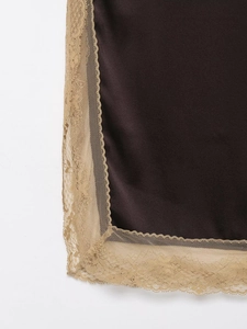 Detail of dark brown satin fabric featuring intricate champagne lace trim stitching