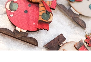 Detailed view of red wooden snowman and penguin ornaments on a snowy background