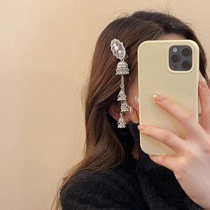 Close-up of vintage silver hair clip with hollow carving and dangling bell tassels