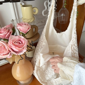 Detail of off-white lace tote bag with daisy embroidery and zippered inner pocket