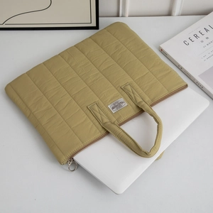 Quilted 13-inch laptop bag in mustard yellow with metal ring zipper and top handle