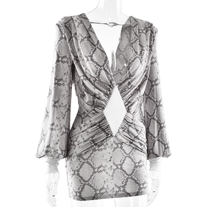 Detailed close-up of snakeskin print dress featuring waist cutout and draped texture
