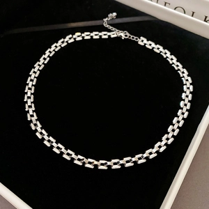 Detailed macro of silver geometric block chain necklace with lobster clasp in a black box