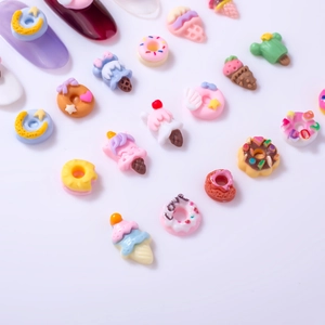 Macro shot of colorful resin donut and ice cream nail art charms in a flat lay arrangement
