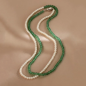Detail of double-layer necklace with white pearls and green agate beads on silk