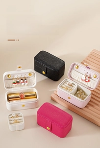 Detail of travel jewelry box showing multi-compartment storage for rings and lipsticks