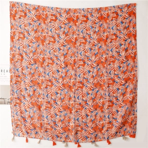 Detail of orange linen shawl with white maple leaf patterns and tassel fringe finish