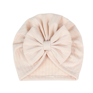 Detail of baby turban hat featuring pink and white striped ribbed fabric with a big bow