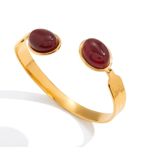 Polished gold stainless steel cuff bracelet featuring two oval red agate stones