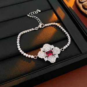 Detail of silver flower bracelet featuring a red rectangular gem and sparkling zircons