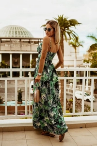 Close-up of bohemian green tropical plant print on a long V-neck sleeveless dress