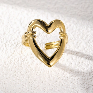 Macro detail of 18K gold-plated heart cutout open ring on textured background