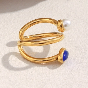 Macro shot of 18K gold plated spiral ring with white pearl and blue lapis lazuli stone