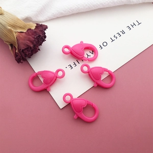 Detail view of pink heart-shaped acrylic lobster clasps for DIY keychains and crafts