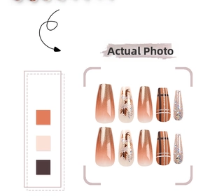 Detail of autumn press-on nails featuring orange gradient, maple leaf art and glitter