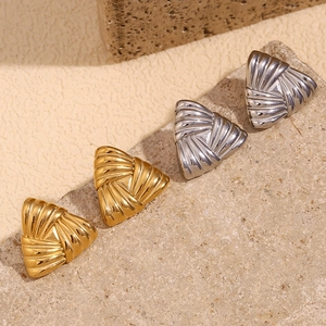 Detail showing gold and silver triangular earrings with textured stripes on stone