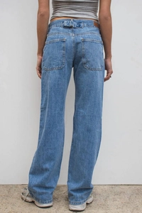 Detail of high waist light blue denim jeans showing back pockets and waist adjusters