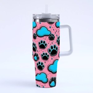 Detail of pink 40oz tumbler with black and blue paw prints, lid and reusable straw