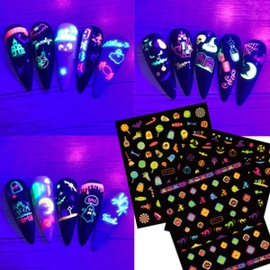 Luminous Halloween nail stickers with glowing ghosts and pumpkins in UV light
