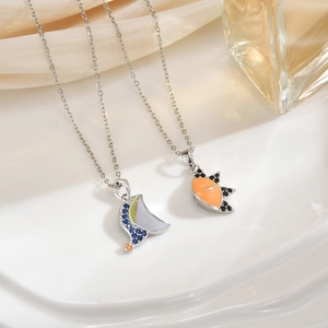Detailed close-up of sun and moon magnetic pendant necklaces on soft silk fabric