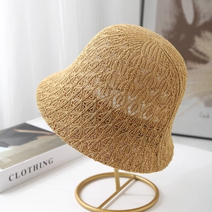 Women hollow-out knit bucket hat in beige displayed on a stand for sun protection