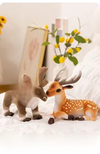 Detailed view of plush reindeer and spotted fawn sitting on a cozy white blanket