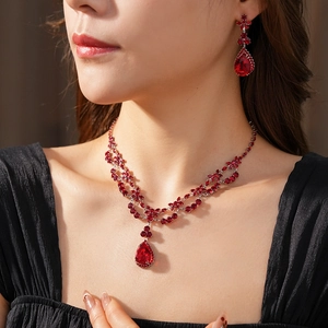 Close-up of luxury red pear-cut zircon floral pendant necklace and earrings set