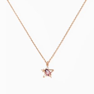 Close-up of 18K rose gold necklace featuring a pear-shaped purple gemstone and star motifs