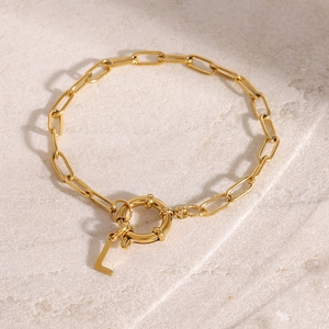 Golden paperclip chain bracelet with a large round spring clasp and a letter L pendant