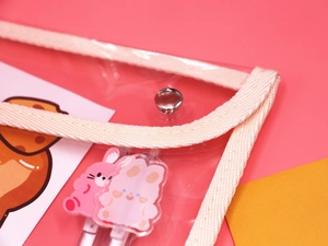 Close-up of clear PVC pencil case showing secure metal buckle and cream fabric edging
