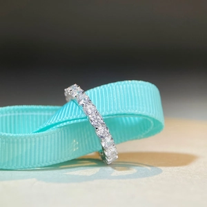 S925 sterling silver moissanite full eternity ring displayed on a soft blue ribbon