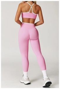 Detail van roze sport-bh met gekruiste bandjes en yoga-legging met hoge taille