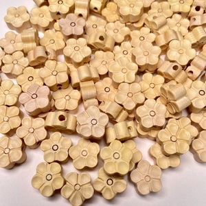Vue détaillée de perles de fleur de prunier en buis sculptées pour bijoux faits main