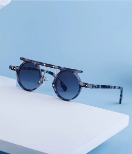 Detail of marble pattern round sunglasses with gold stars and blue gradient lenses