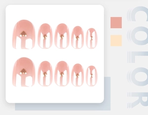 Close-up of pink French tip press-on nails with golden heart metal sequins decoration