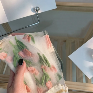 Vue détaillée de chaussettes transparentes avec motifs de tulipes roses en 3D