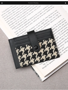 Close-up of slim leather card holder featuring houndstooth pattern and button clasp closure