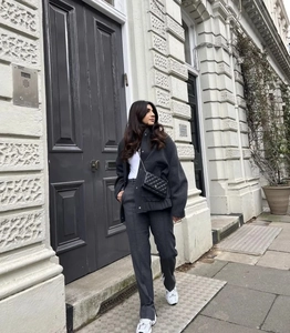 Outdoor street view of dark grey wool blend coat with relaxed fit and minimalist urban style