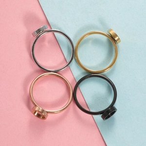 Flat lay of four round stainless steel ring blanks in silver, gold, rose gold and black