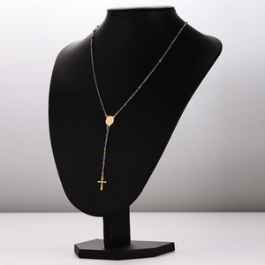 Gold Y-shaped rosary necklace with blue beads and cross pendant on a display stand