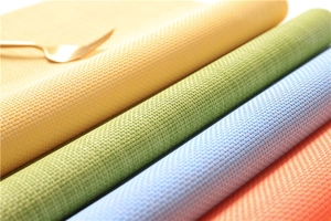 Close-up of four colorful woven PVC placemats showing detailed heat resistant texture